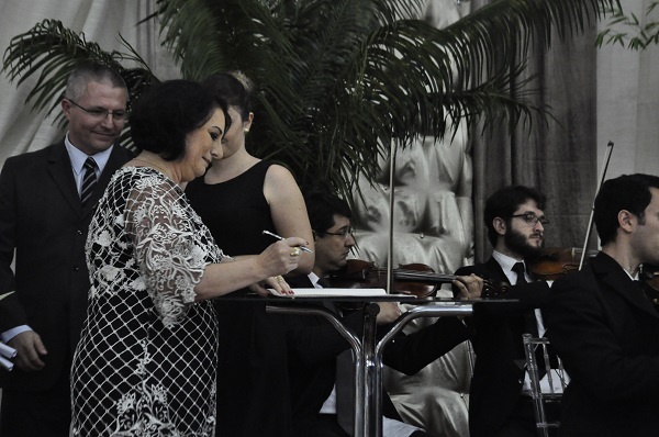 Carmen Lúcia assinando a ata de posse ao som da Orquestra de Câmara da Unisc