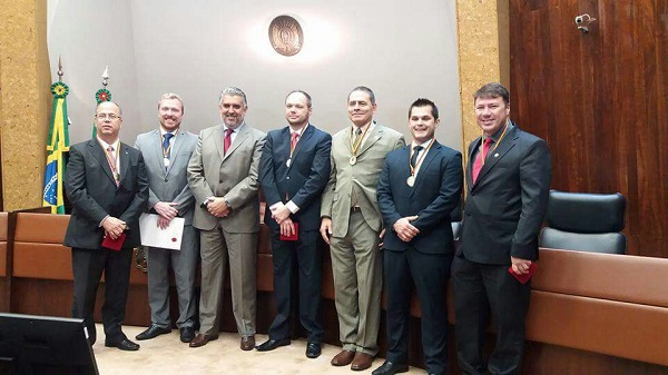 Delegado Gustavo Schneider (à dir.) ao receber homenagem 