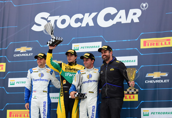 Marcos Gomes ergue o troféu da primeira prova, junto com Daniel Serra - esquerda -, e Max Wilson