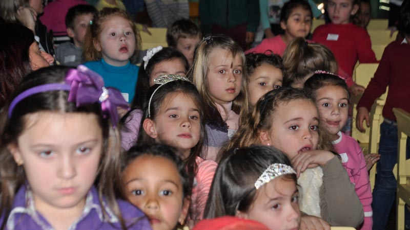 Crianças assistem ao filme com toda a atenção que a arte cinematográfica requer