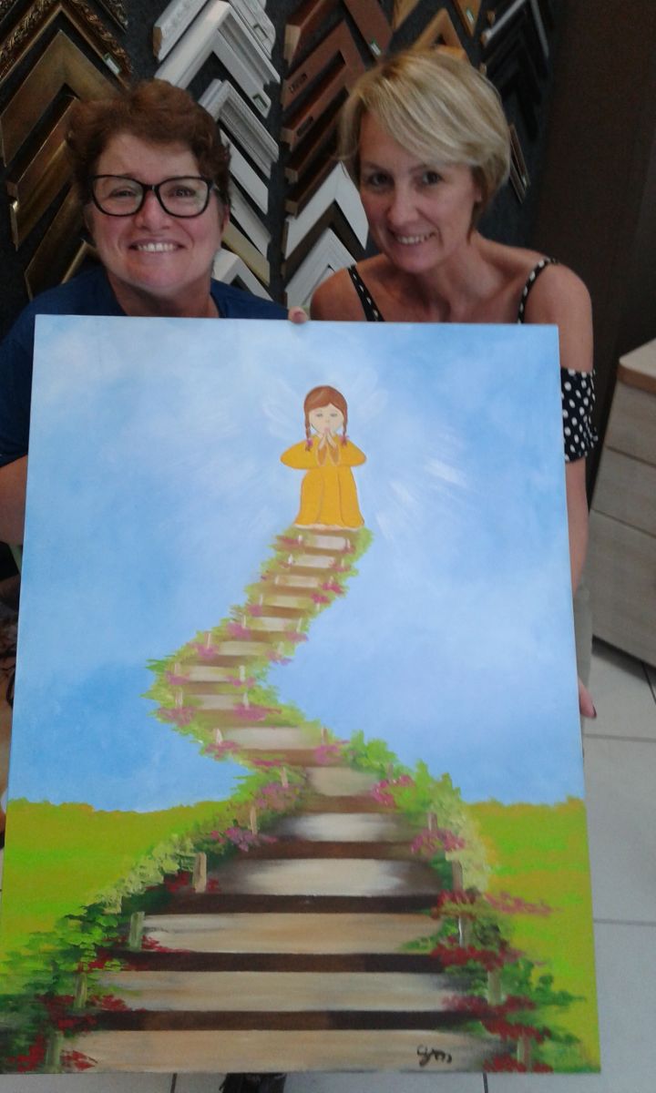 Casandra Meirelles (à esquerda) com a professora Noeli Krumenauer (à direita) e um de seus quadros como fonte de inspiração e superação de uma família impulsionada pelo tratamento com células-tronco e de reabilitação multidisciplinar.