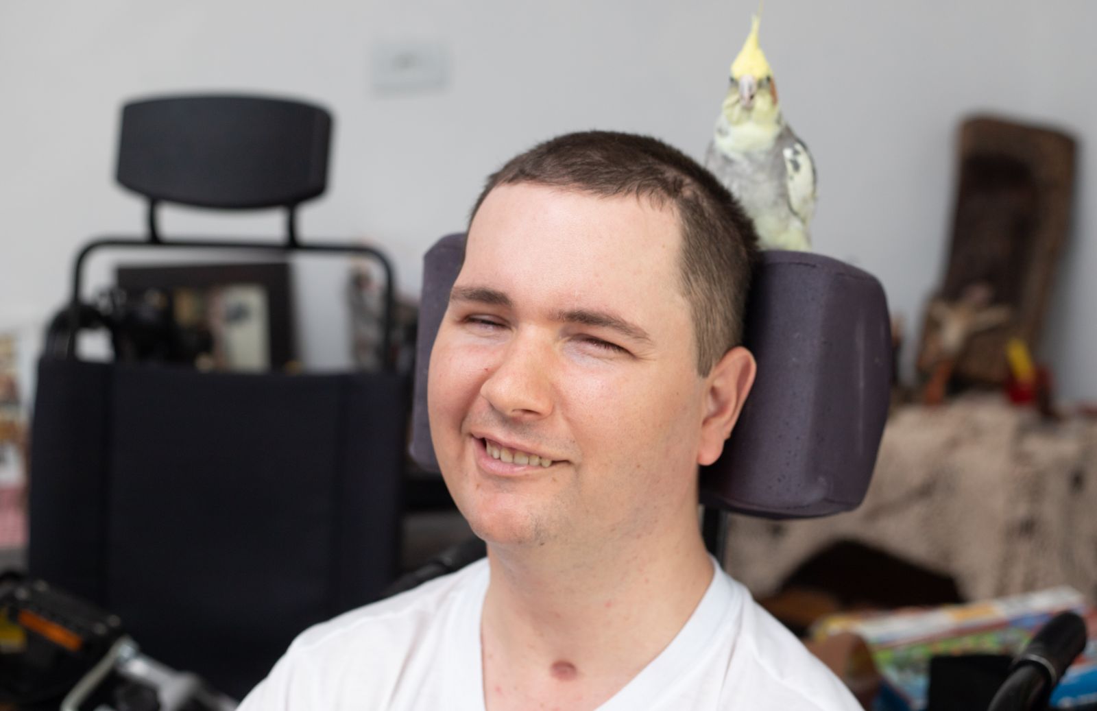 Fernando Goerck Kappel e sua companheira, a calopsita Mel. Jovem teve melhora após tratamento na Tailândia e família pretende retornar para novas aplicações