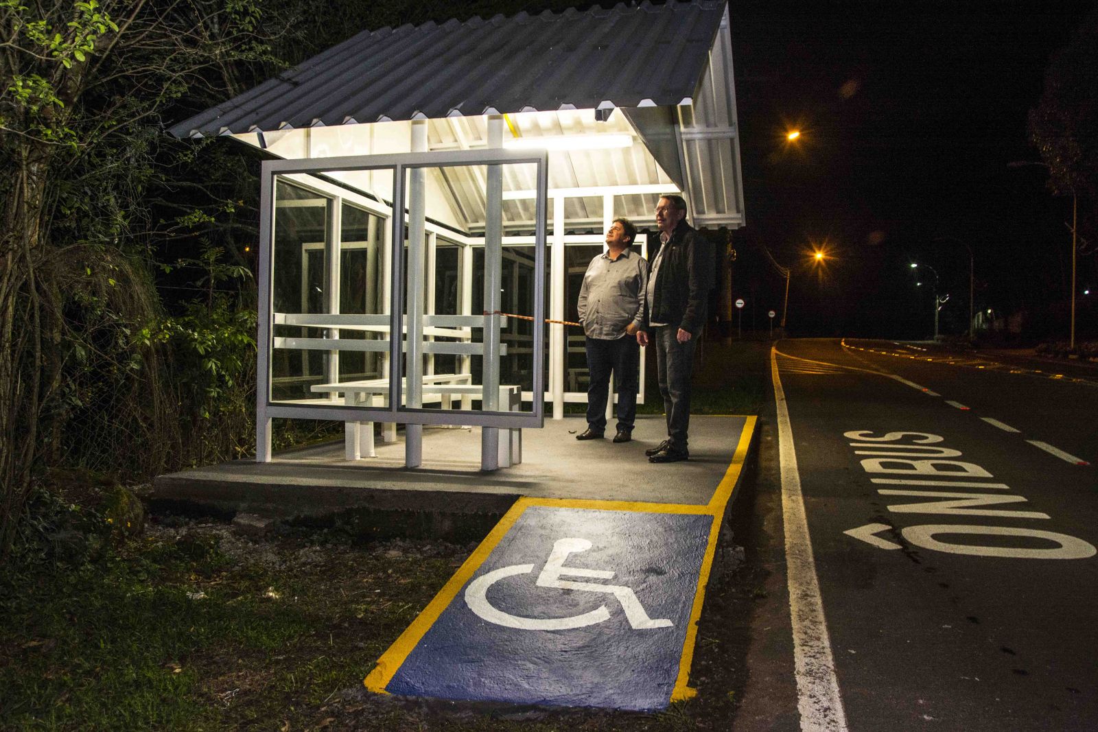 Envidraçado, com iluminação, rampa de acessibilidade e piso de concreto